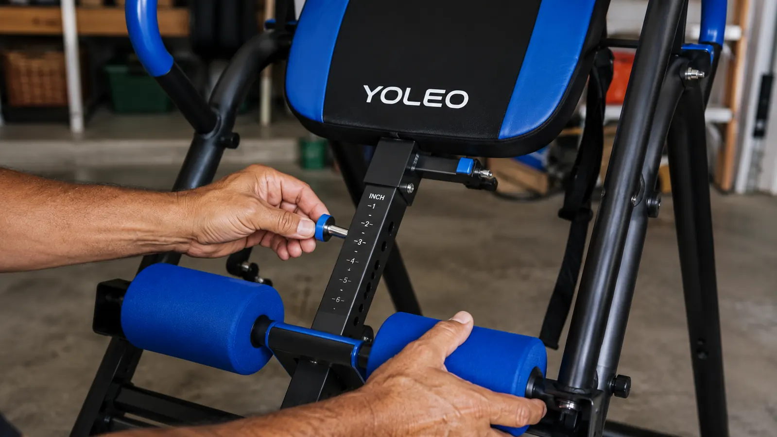 Close-up of hands locking the ankle cushions and checking the height pin on the YOLEO inversion table before a session